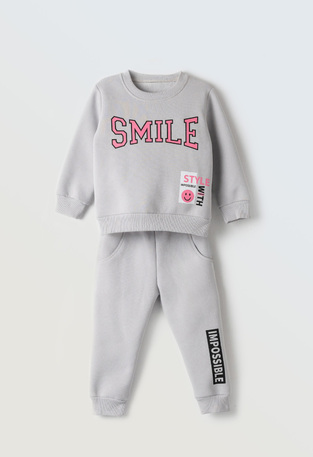 EBITA tracksuit set in gray with "SMILE" logo embossing.