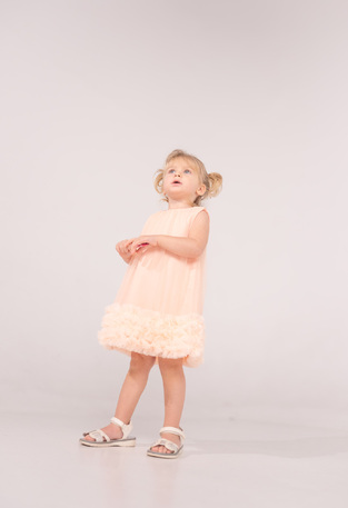 EBITA tulle dress in salmon color with ruffles at the hem.