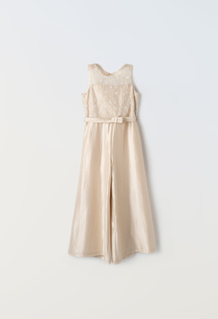 EBITA jumpsuit in beige metallic color with lace details.